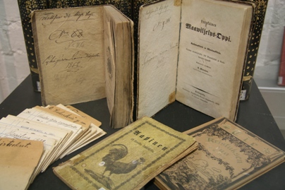 Kellastuneita 1800-luvun kirjastokirjoja esillä näyttelyvitriinissä.